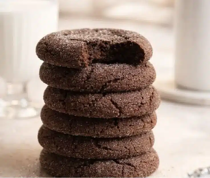 Fudgy chocolate sugar cookies on a plate with a glass of milk