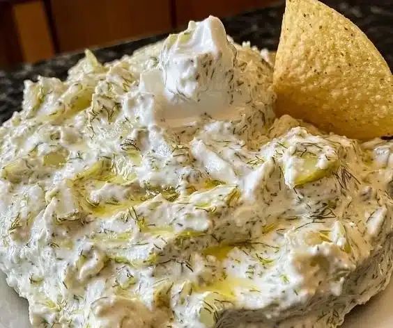 Creamy Dill Pickle Dip served with chips and fresh vegetables for a tasty snack.