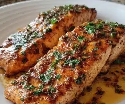 Grilled Texas Roadhouse style salmon served on a plate with fresh herbs