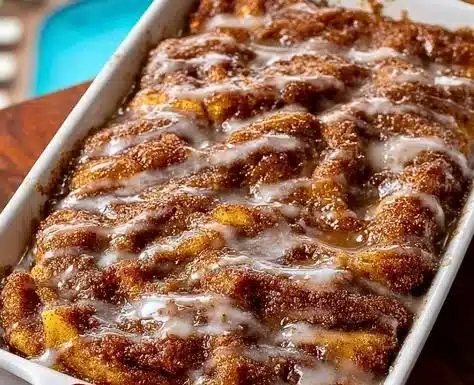 Slice of homemade Apple Fritter Cake topped with glaze and cinnamon