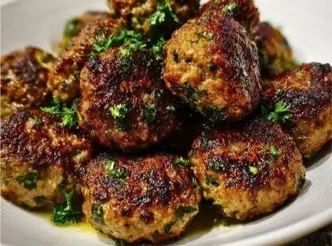 Delicious Baked Beef Kofta served with fresh herbs and dipping sauce.