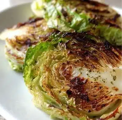 Delicious Roasted Garlic Cabbage Steaks served on a wooden plate
