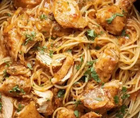 Delicious slow cooker chicken spaghetti served in a bowl with herbs